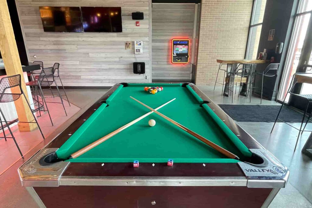 pool table near the bar with seating and TVs